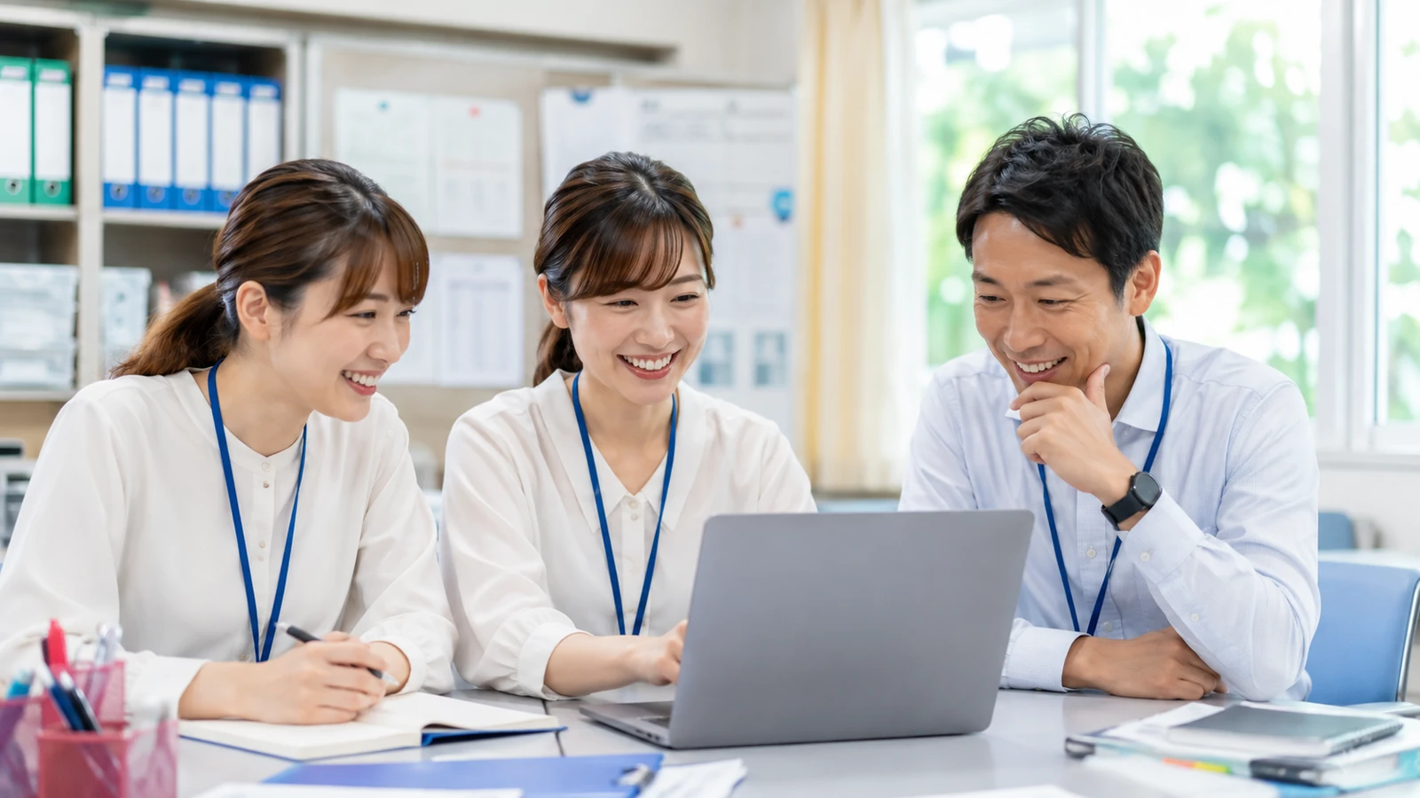 学校担当者がパソコンで学校写真を整理するイメージ